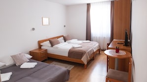 Une chambre d’hôtel avec deux lits, un bureau et une chaise.