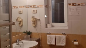 Une salle de bain avec un lavabo, des toilettes et une fenêtre.
