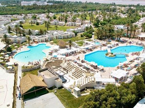 A resort with multiple swimming pools, outdoor seating areas, and a large covered structure. - One Resort Aqua Park & Spa (Monastir)