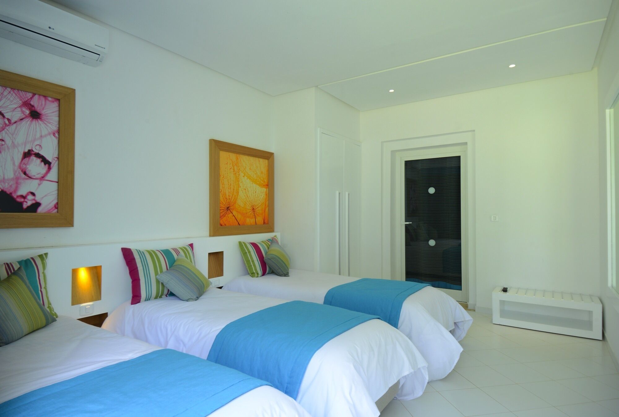 A hotel room with two beds, a large window, and a door.
