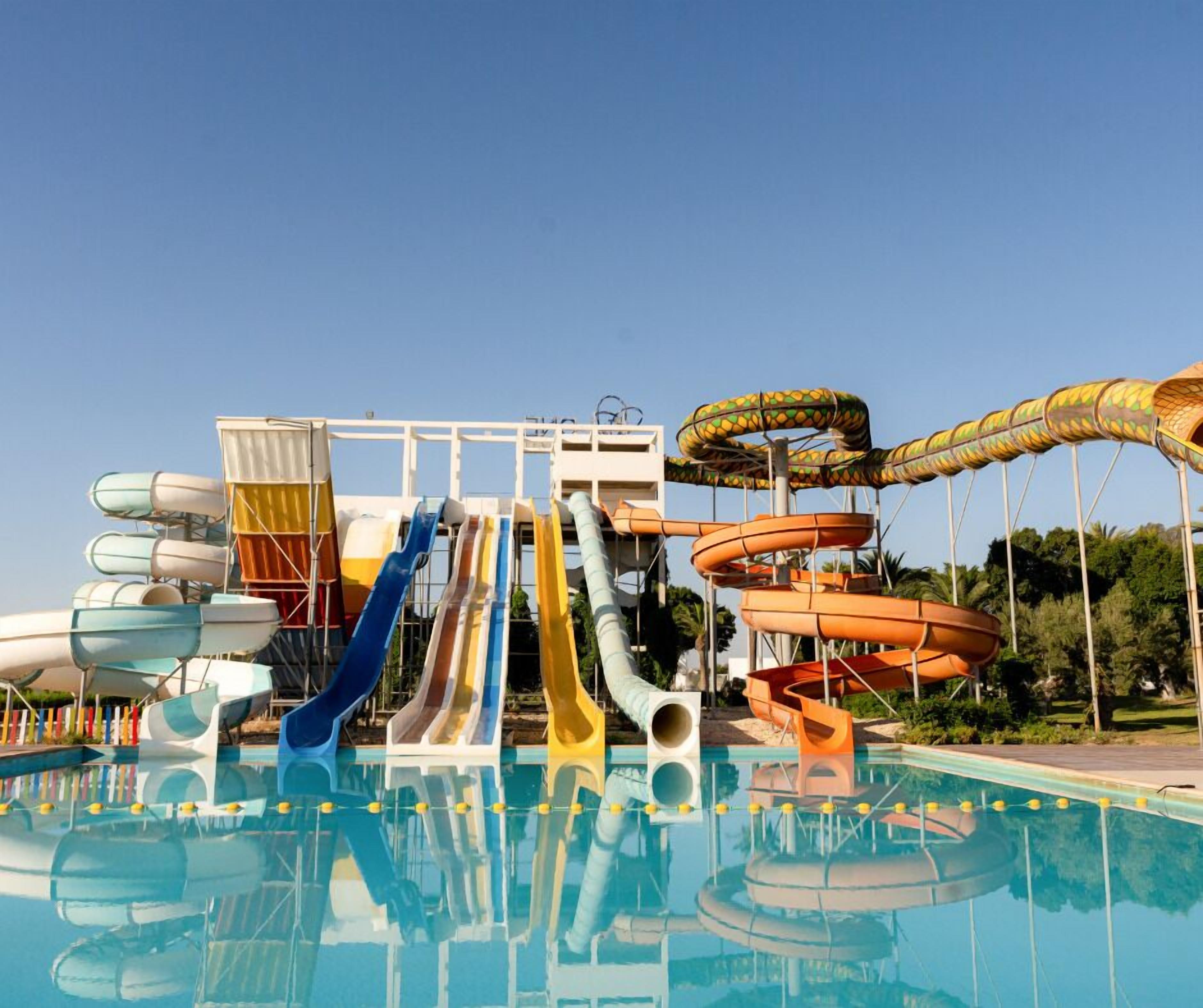 Un parque acuático con múltiples toboganes y piscina.