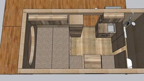 Un plan d’étage en 2D d’une pièce compacte et moderne, comprenant un coin cuisine, une petite salle de bain et un espace salon.