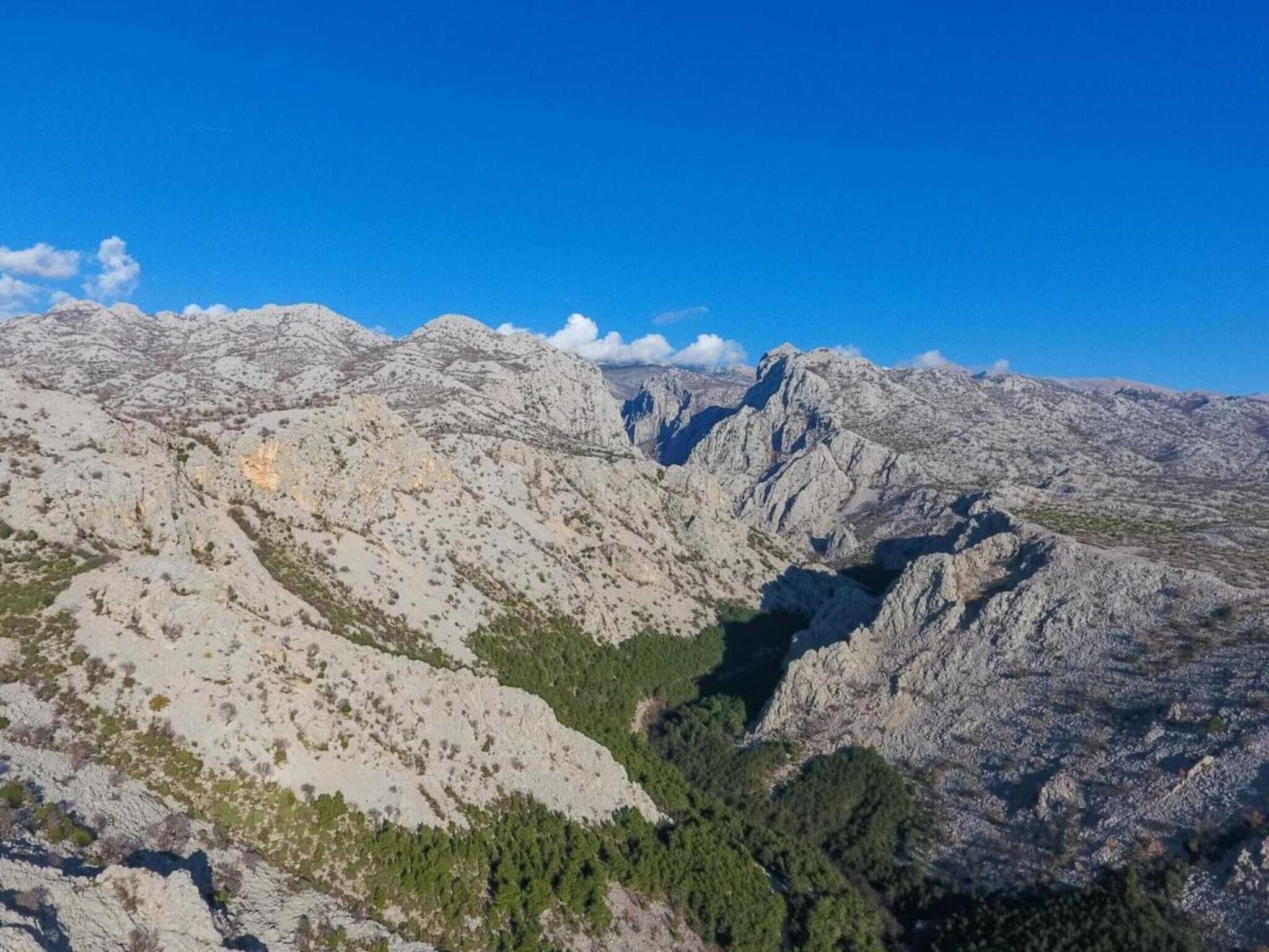 A mountainous landscape with rocky terrain and sparse vegetation.
