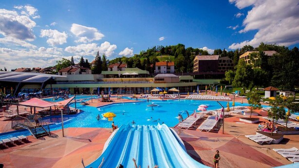 A large outdoor swimming pool with multiple slides and sun loungers. - Charming Stay in Sveti Križ (Tuhelj)