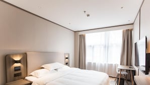 Een moderne hotelkamer met een groot bed, nachtkastjes, een bureau en een televisie.