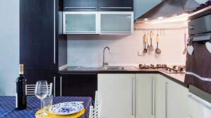 A compact kitchen with dark cabinets, a stainless steel sink, and a gas stove. - Countryside Home in Arezzo with Pool (Tregozzano, Arezzo)