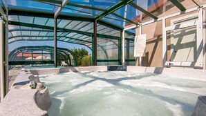 A hot tub area with a glass enclosure, a pool, and a lounge chair. - Panoramic Countryside Home (Apecchio)