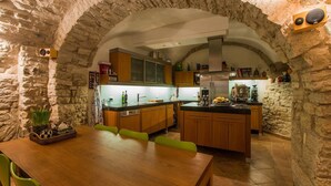 Una cocina rústica con paredes de piedra, armarios de madera y una isla central.