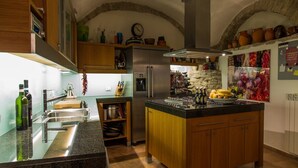 Una cocina moderna con una isla central, electrodomésticos de acero inoxidable y un arco de piedra.