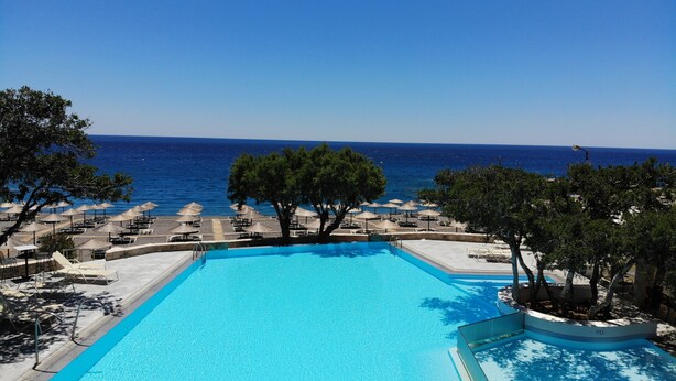 A pool with a view of the sea, surrounded by lounge chairs and umbrellas. - Kakkos Bay (Ierapetra)