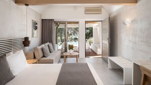 A modern bedroom with a bed, a sofa, a desk, and a view of the outdoors. - Kakkos Bay (Ierapetra)