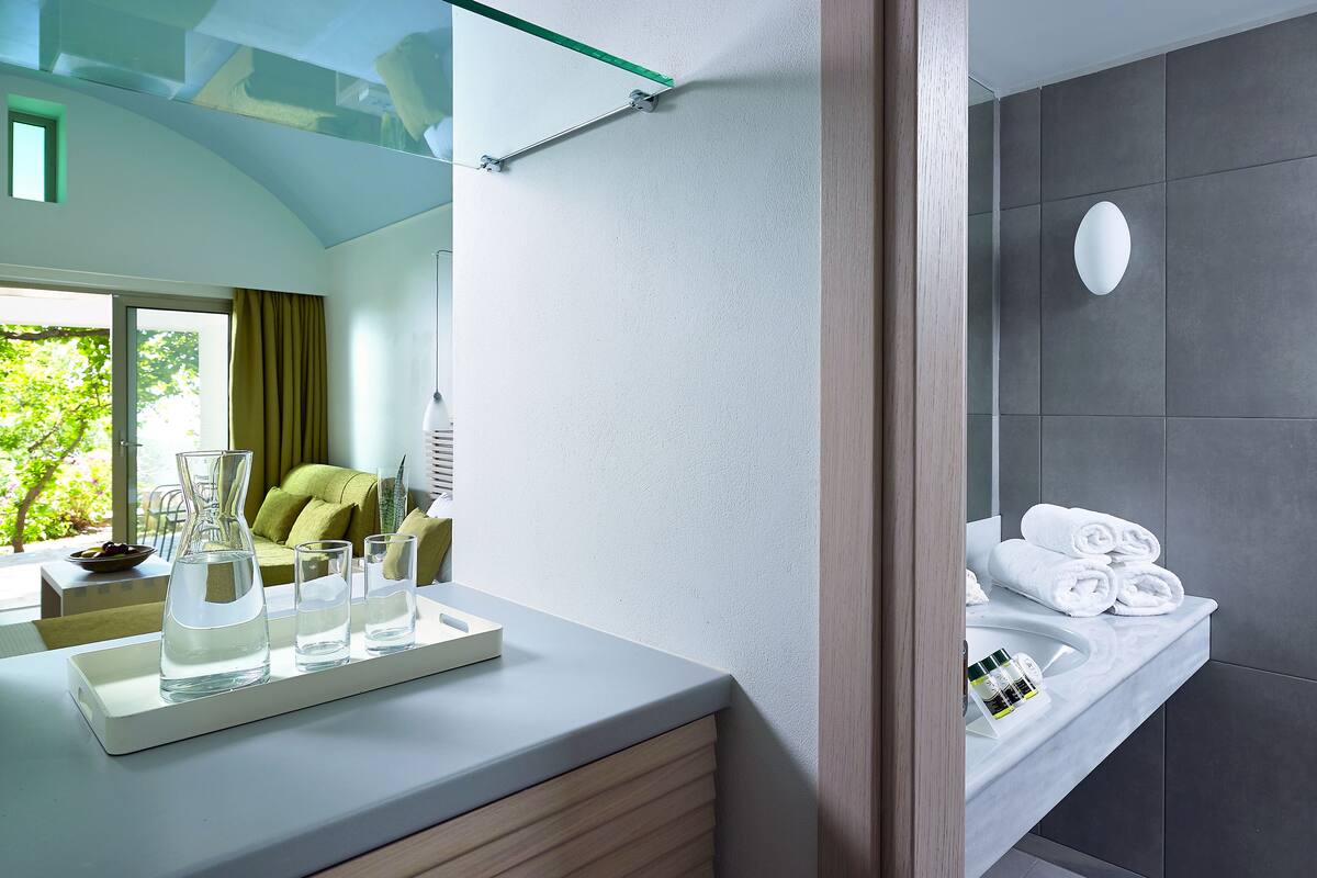 A modern bathroom with a white countertop, a glass shower enclosure, and a towel rack.