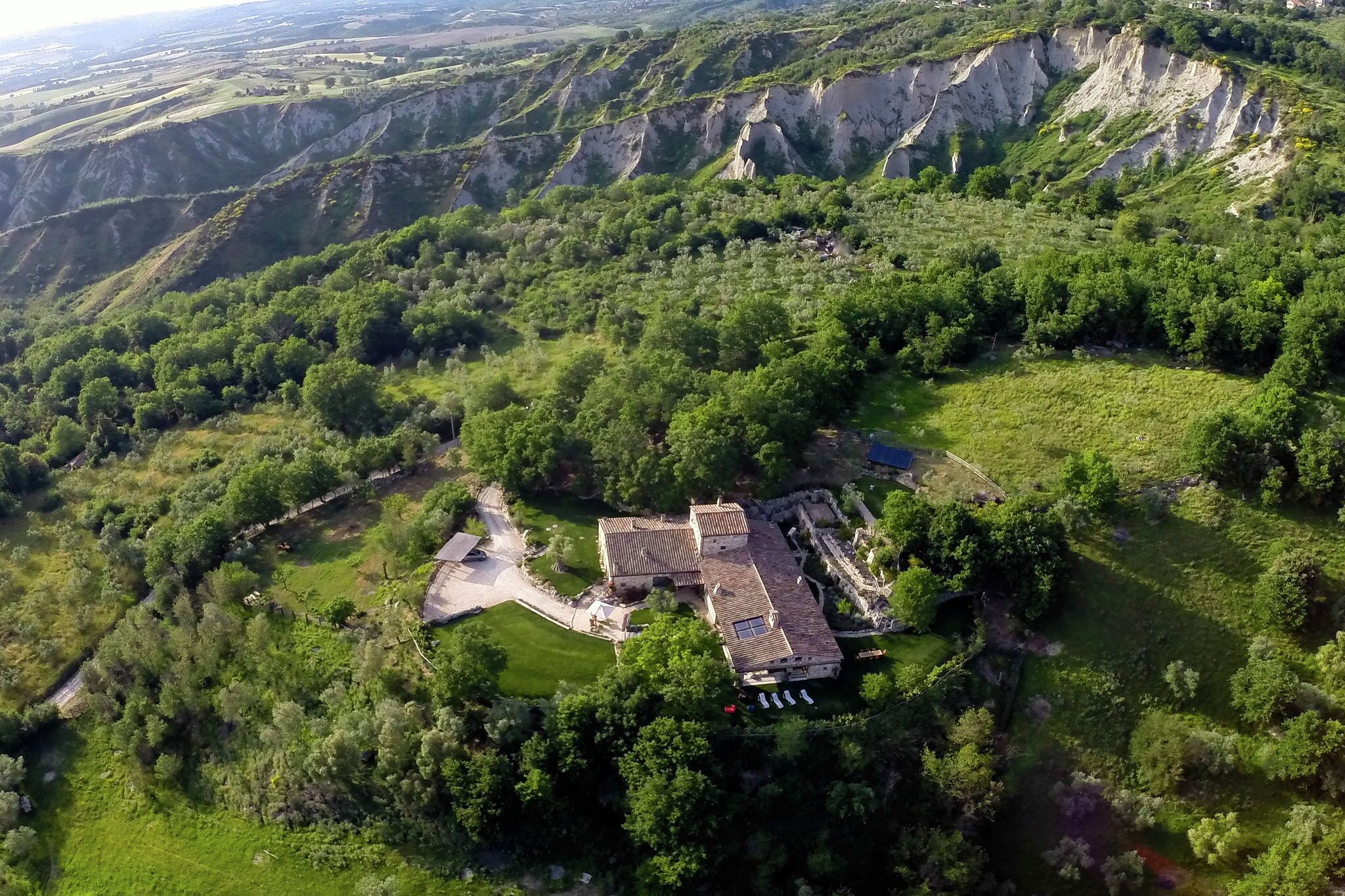 An aerial view of a historic building surrounded by lush greenery and terraced fields.