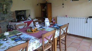 Ein Essbereich mit einem Tisch für zwei Personen, umgeben von Holzstühlen. Im Hintergrund sind ein Holzschrank und eine Heizung erkennbar.