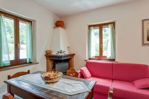 Une pièce chaleureuse avec une cheminée, un canapé rouge et une table à manger avec un set de table.