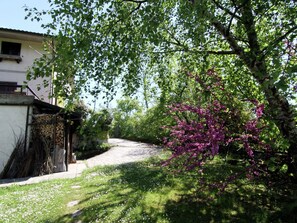 A paved pathway leading to a building with a white exterior and a window. - Belvilla by OYO Il Cerro (Bardalone)