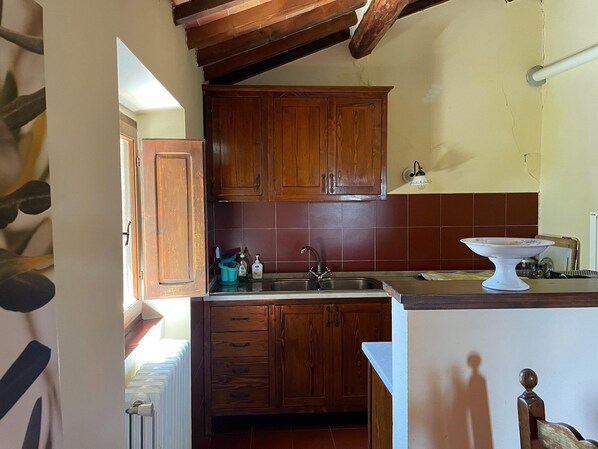 Une cuisine avec des meubles de rangement en bois, un évier et un plan de travail.