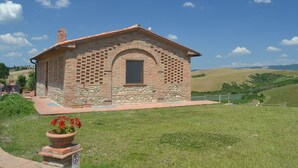 A small stone building with a tiled roof, a window, and a brick pathway leading to it. - Belvilla by OYO Gatterino (Peccioli)