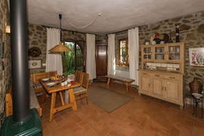 Eine rustikale Küche mit einer Steinwand, Holzmöbeln und einem eingebauten Schrank mit Glastüren.