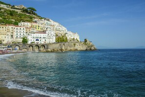 A coastal town with colorful buildings, a beach, and a sea wall.