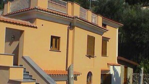 Un edificio de dos pisos con una escalera que conduce a la entrada.