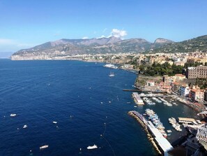 Une ville côtière dotée d’un port de plaisance, de bateaux et bordée de montagnes.
