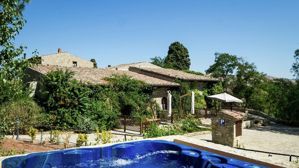 A traditional stone building with a swimming pool and a hot tub.