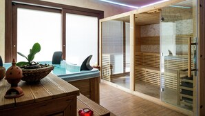 A modern spa room with a wooden bench, a hot tub, and a glass-enclosed sauna area.