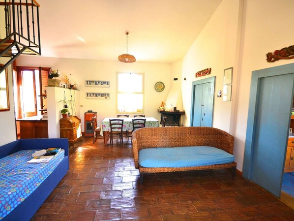 Una sala acogedora con un sofá, una mesa de comedor y una escalera.