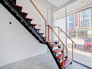 Un escalier avec des marches en bois et des rampes en métal, situé à l’intérieur d’un bâtiment.