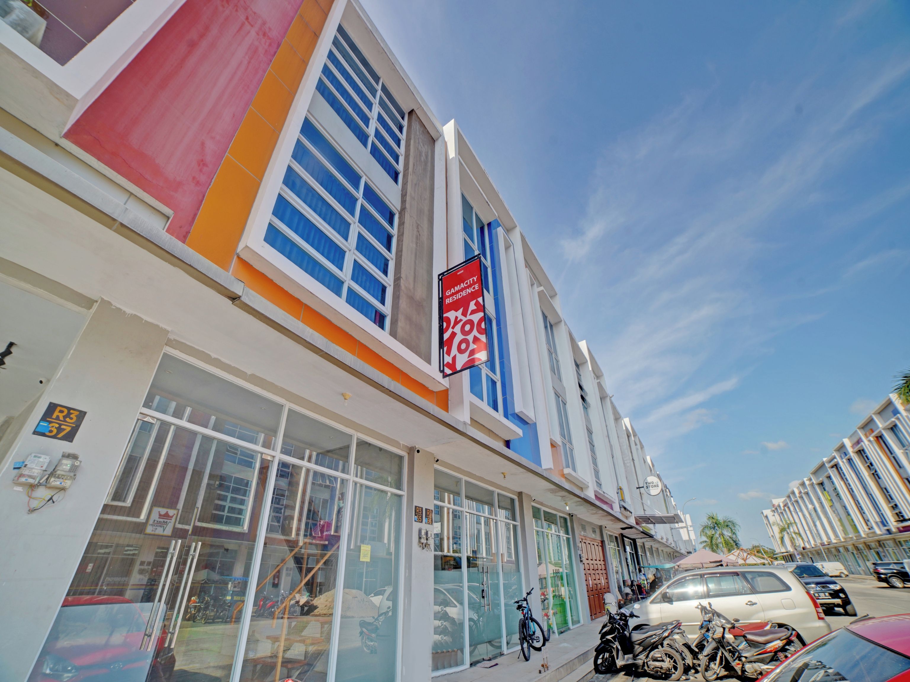 A modern building with large windows and a sign for a guesthouse.