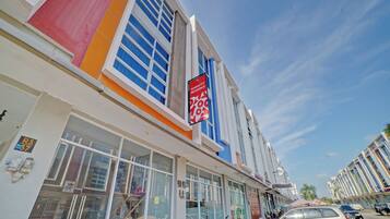 A modern building with large windows and a sign for a guesthouse.