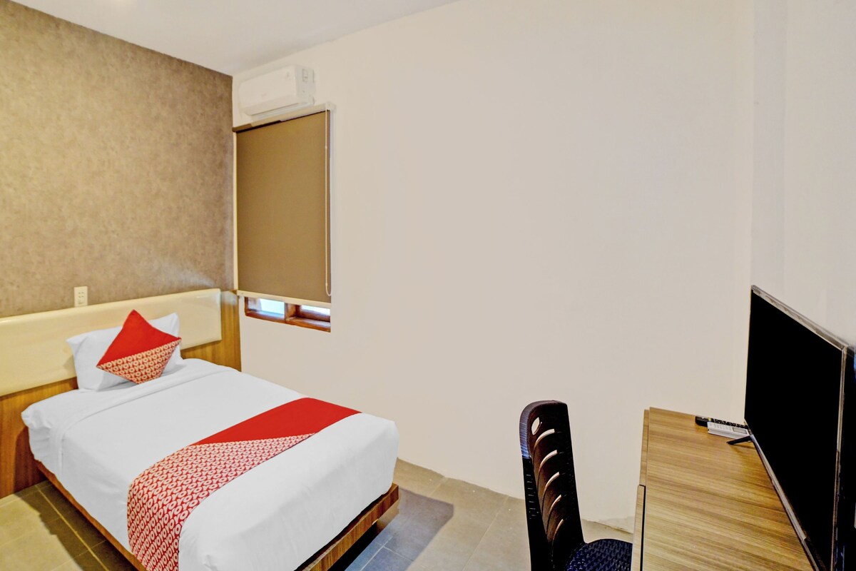 Une chambre d’hôtel équipée d’un lit, d’un bureau, d’une chaise, d’une télévision et d’un appareil de climatisation.