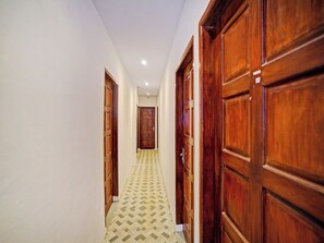 Un couloir avec des portes en bois et un revêtement de sol à motifs.