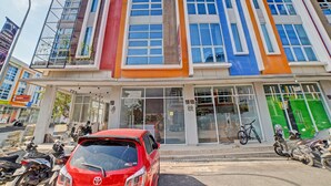 A multi-story building with a modern design, featuring large windows and a variety of colors on the facade. - OYO 90559 Gamacity Residence (Medan)
