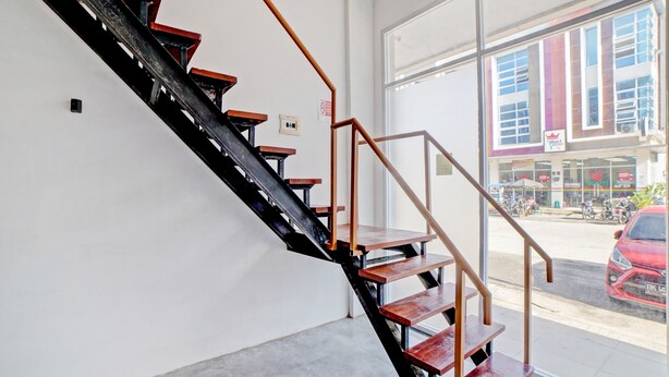 A staircase with wooden steps and metal railings inside a building. - OYO 90559 Gamacity Residence (Medan)