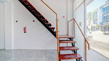 A staircase with a metal railing and wooden steps leading to an upper floor.