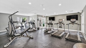 Ein Fitnessstudio mit Laufbändern, Crosstrainern und Gewichtsmaschinen.