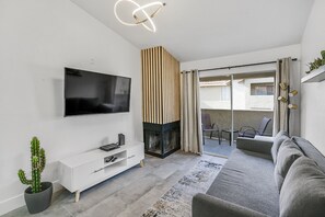 Relax in this stylish living room with a flat-screen TV, fireplace, and comfortable sofa.