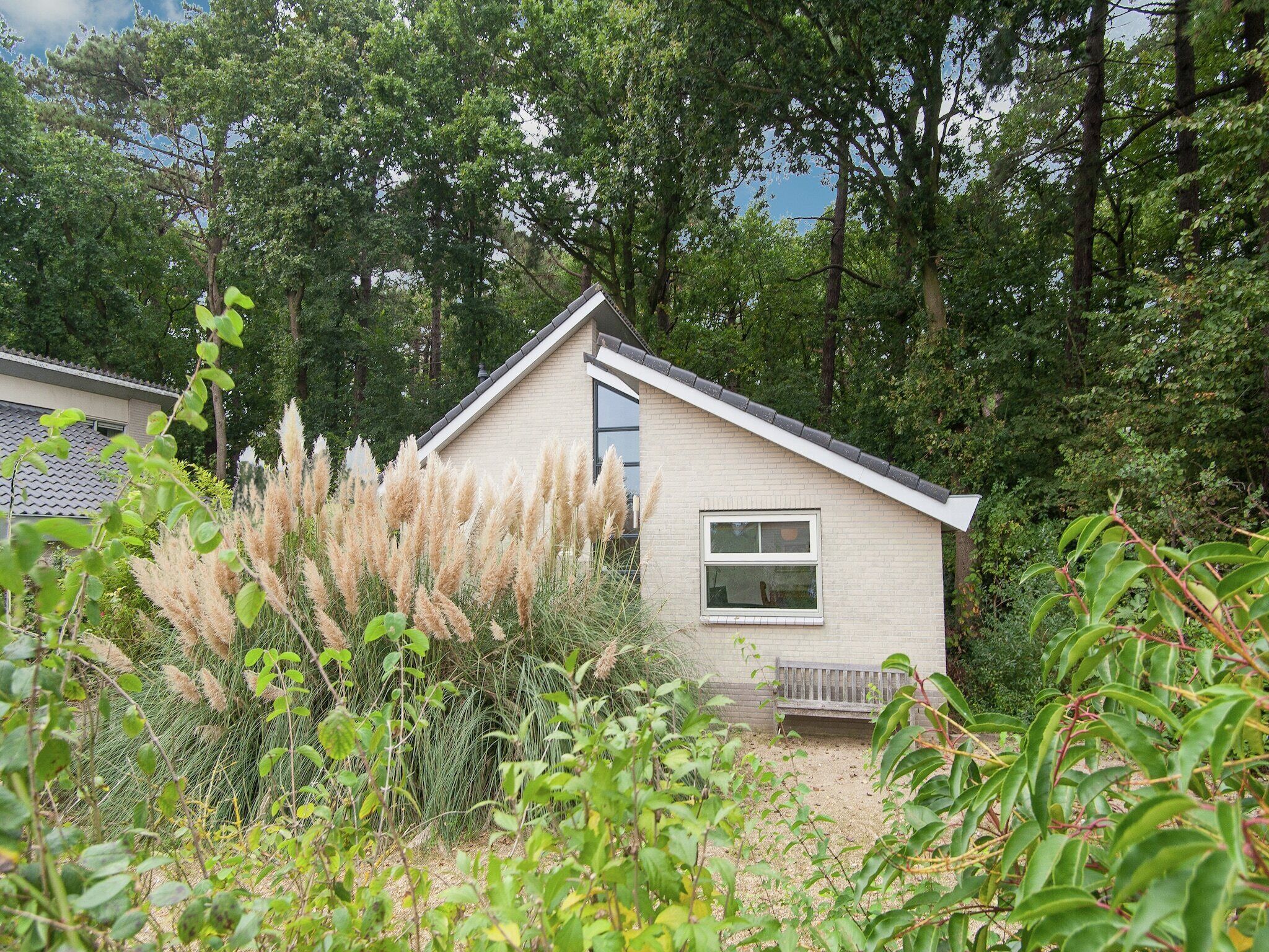 A small house with a sloped roof, a window, and a bench in front.