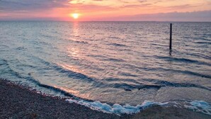 Un tramonto sull'oceano con le onde che accarezzano dolcemente la spiaggia.