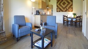 Una sala de estar con dos sillones, una mesa de centro y una zona de comedor con mesa y sillas.