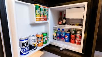 An open refrigerator stocked with various beverages including Perrier, Tecate, Corona, and Fiji.