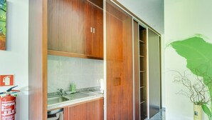 Una cocina moderna con armarios de madera, un lavamanos y un extintor.