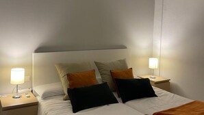 Et hotelværelse med en seng, to sengeborde og to læselamper.