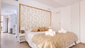 Une chambre d’hôtel avec un grand lit, une table de chevet, une lampe et une armoire.