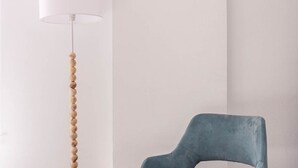 Une pièce moderne avec un lampadaire blanc et une chaise bleue.