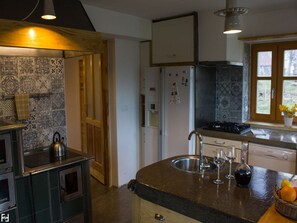 A kitchen with a stove, sink, and refrigerator. There is a window with a view of the outdoors. - Holiday Home in Bunjevci with Sauna & Garden (Vrbovsko)
