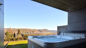 A hot tub with a view of a hilly landscape. - Luxurious Cottage in Aywaille with Sauna (Aywaille)