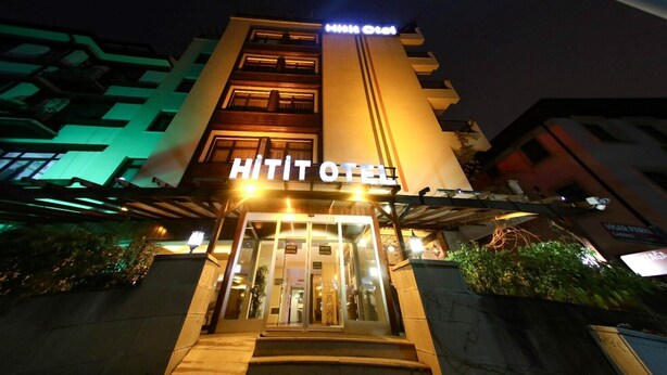 The exterior of a hotel with a prominent 'HITIT HOTEL' sign, a glass entrance, and a staircase leading to the lobby. - Hitit Otel (Ankara)